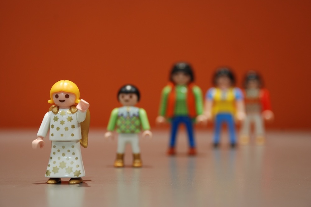 Des figurines Playmobil l'une devant l'autre, une femme à l'avant un bras en l'air