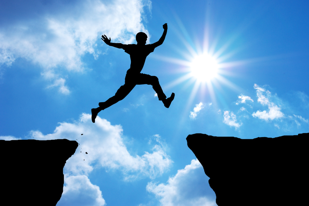Photo d'un homme sautant d'un rocher à l'autre pour illustrer que le changement est possible, si l'on s'y prépare bien