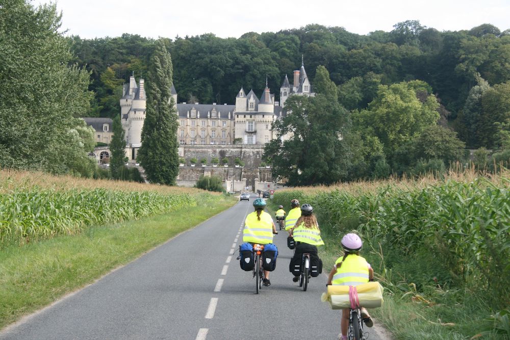 Famille en randonnée cyclotouriste se dirigeant vers un château Renaissance